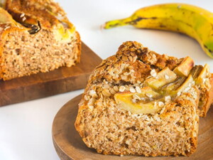 Bolo de banana com aveia, servidos em dois recipientes com uma banana ao fundo